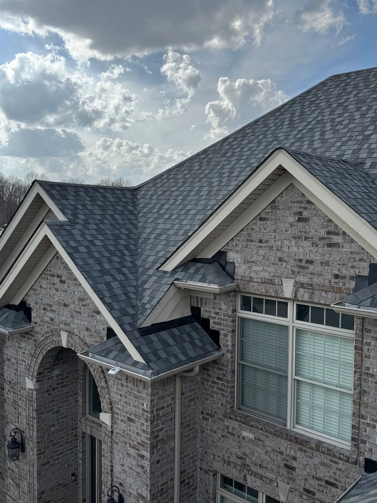 Finished roof on a gray brick home